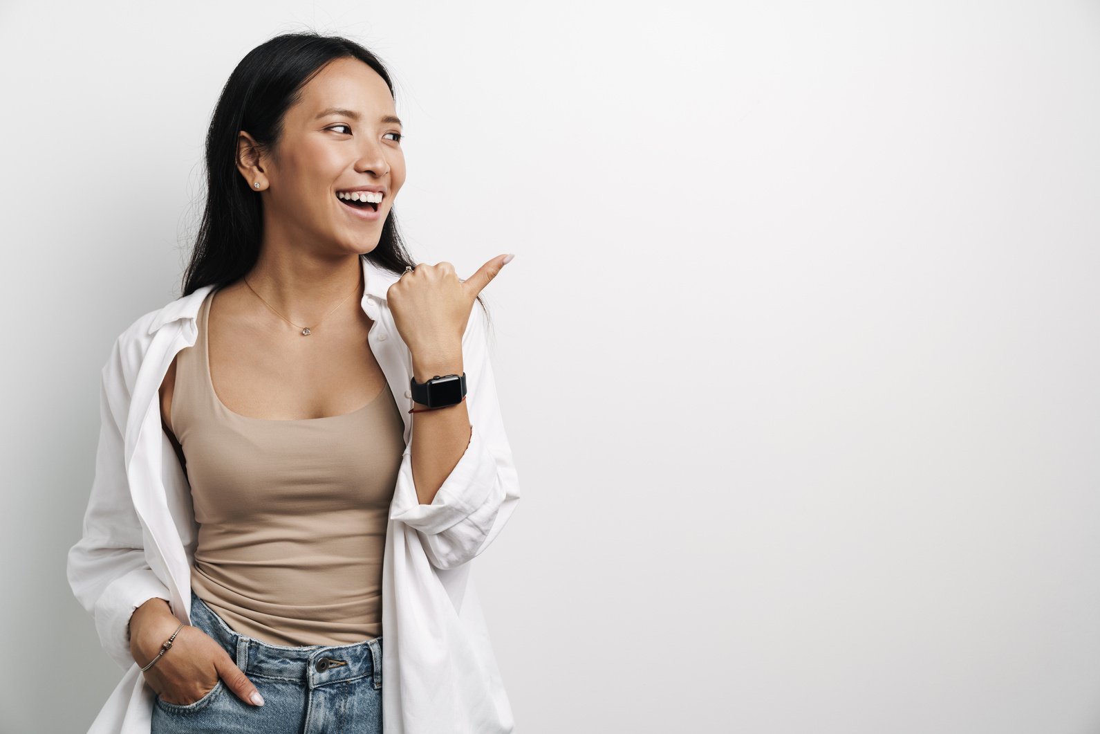 Beautiful Happy Asian Woman Laughing and Pointing Finger Aside